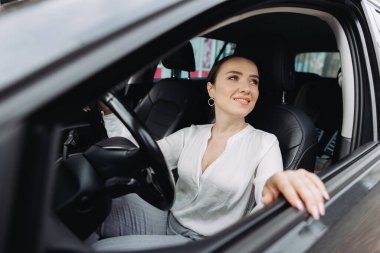 Şehirde araba süren genç bir kadın..