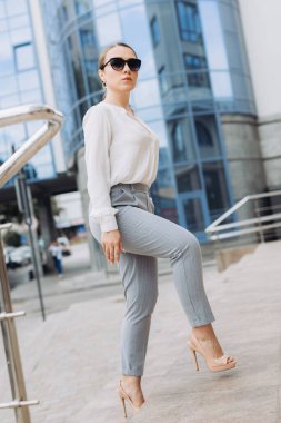 Güzel bir kadın işe gidiyor, ofis binasının yanında yürüyor..