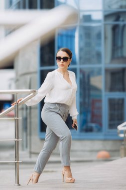 Güzel bir kadın işe gidiyor, ofis binasının yanında yürüyor..