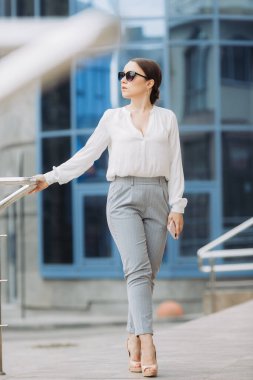 Güzel bir kadın işe gidiyor, ofis binasının yanında yürüyor..