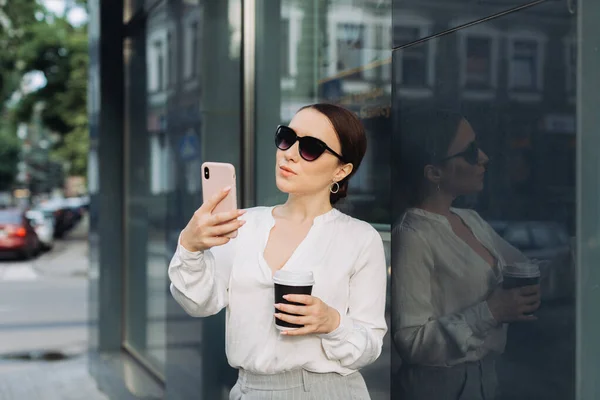 Tiro Sonriente Joven Mujer Negocios Usando Teléfono Móvil Mientras Bebe — Foto de Stock