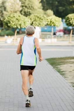 Yaşlı adam temiz havada koşmakla meşgul. Yüksek kalite fotoğraf