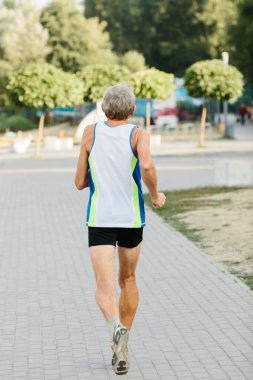 Yaşlı adam temiz havada koşmakla meşgul. Yüksek kalite fotoğraf