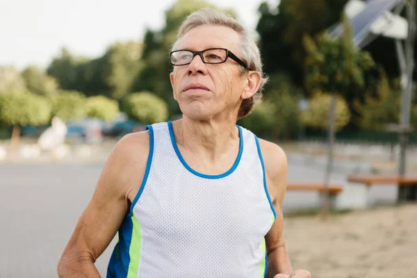 Homem mais velho está envolvido em correr ao ar livre — Fotografia de Stock