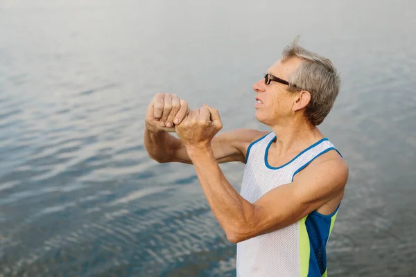 Homem sênior está envolvido em esportes no dique do lago — Fotografia de Stock
