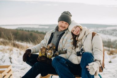 Mutlu baba ve kız karda dinleniyor, aile bağlarını ve sıcaklığı kucaklıyor kış macerası boyunca.