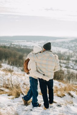 Sevgi dolu baba ve kız sıcak bir kucaklaşmayı paylaşıyor ve manzaranın tadını çıkarıyor.