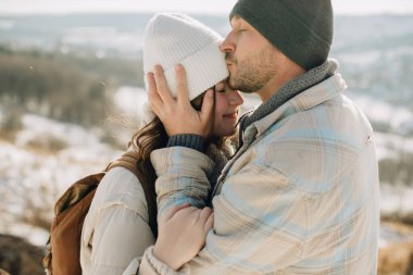 Baba ve kızı, karlı bir kış gününde kucaklaşıp, şefkat ve şefkat dolu bir anı paylaşıyorlar.