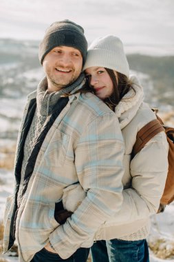 Baba ve kızı sıcak bir kışı paylaşıyorlar. Açık havada kucaklaşıyorlar. Karlı bir kırsal alanda gülüyorlar ve kaynaşıyorlar.