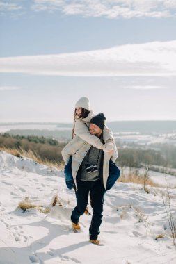 Baba, kızını karlı kış tepesinde sırtında taşıyor. Köpekle dışarıda eğleniyor ve ailecek vakit geçiriyor.