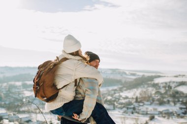 Genç bir baba, kızını karlı bir tepede sırtında taşırken, kış macerasında birlikte vakit geçirirken.