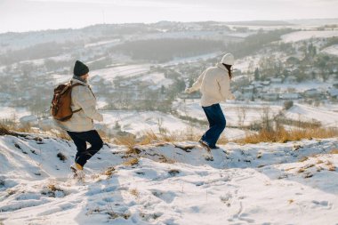 Mutlu baba ve kızı karla kaplı arazide oynuyorlar. Aile açık hava aktivitelerini ve temiz havayı seviyor.