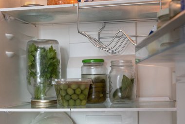 Kavanozda taze maydanoz ve buzdolabında su var. Düzgün bitki depolama, tazelik koruma ve evde gıda organizasyonu kavramı.