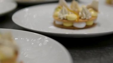 Sarı soslu, beyaz peynir ve ahşap masaya konmuş mor çiçeklerle süslenmiş bir tatlı tabağı manzarası. Yüksek kalite 4k görüntü