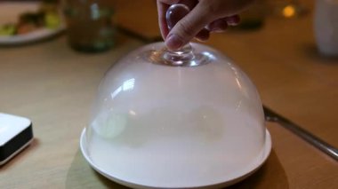 Duman dolu cam bir kubbenin altında servis edilen kırmızı balık filetosu açılır, sonra canlı yeşil bir sos serpiştirilir sanatsal moleküler mutfak kaplaması çarpıcı bir şekilde yemek gurmesi sahnesini gözler önüne serer.