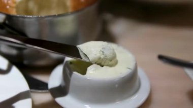 Taze pişmiş börekler bir kaşıkla alınır ve kremalı tereyağlı, zarif bir kahvaltı veya brunch sunumu ile sergilenir..