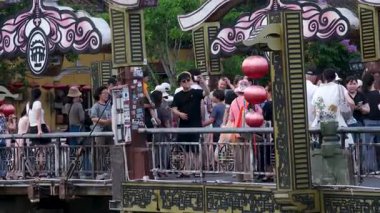 Otantik Hoi Bir Vietnam yaşam tarzı turistlerin canlı kültürel seyahat sahnelerinde yürüdüğü eski şehir caddeleri nehirde yüzen tekneler ve kafede eğlenen insanlar. Hoi Bir Vietnam 10.02.2025