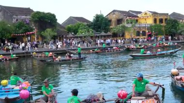 Otantik Hoi Bir Vietnam yaşam tarzı turistlerin canlı kültürel seyahat sahnelerinde yürüdüğü eski şehir caddeleri nehirde yüzen tekneler ve kafede eğlenen insanlar. Hoi Bir Vietnam 10.02.2025