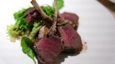 Soslu kuzu pirzola ve bir restoranda tabakta salata yakın. Yüksek kalite 4k görüntü