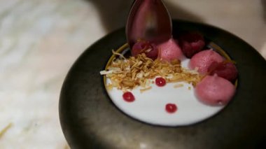 Elma soslu, ahududu ve muzlu lezzetli yoğurt tatlısı. Adım adım talimat veriyorum. Adım 8. Tatlıyı ahududu ve nane yapraklarıyla süsleyin. Yüksek kalite 4k görüntü