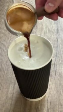 Kağıt bardak kahve makinesi kırmızı kağıt bardağa espresso dağıtıyor, demleme işlemine yakın çekim, modern kafe ortamında sıcak içecek hazırlığı, dumanı tüten espresso içkisi pürüzsüz akıyor..