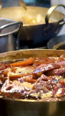 Sıcak et ve havuç kaynatıyorlar, aromatik buharı kırsal dökme demir tencereye salıyorlar, doyurucu mutfak pişirme sürecini zengin mutfak sıcaklığı ve geleneksel lezzetle yakalıyorlar. Yüksek kalite 4k görüntü