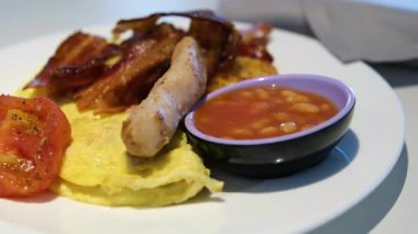 Geleneksel İngiliz kahvaltısı. Ulusal İngiliz mutfağı, domuz pastırması ve sosisli sahanda yumurta, tabakta tost. Amerikan barı ya da... Yüksek kalite 4k görüntü