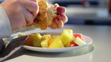 Taze bir kruvasanı çikolatayla parçalarken yavaş çekimde yakın plan çekimde yumuşak dokuyu yakalıyor ve ilk ısırıktan önce tatlı bir beklenti içinde. Yüksek kalite 4k görüntü