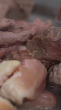 Kızarmış et. Aşçı, et parçalarını soğanla karıştırıp gaz sobasında kızartma tavasına koyar. Yüksek kalite 4k görüntü