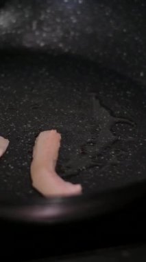 Kızarmış et. Aşçı, et parçalarını soğanla karıştırıp gaz sobasında kızartma tavasına koyar. Yüksek kalite 4k görüntü