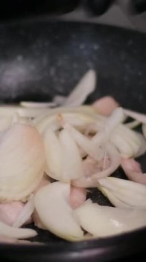 Kızarmış et. Aşçı, et parçalarını soğanla karıştırıp gaz sobasında kızartma tavasına koyar. Yüksek kalite 4k görüntü