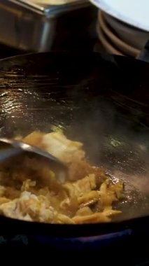 Ticari bir mutfaktaki dökme demir bir tavada sığır eti ve sarımsakla kızartılmış sebze kızartmak, flambe tarzı pişirmek. Kapatın. Yüksek kalite 4k görüntü