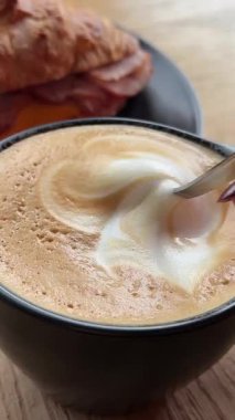 Kaşık kekiyle kahveyi karıştırır sıcak atmosferin yanında sabah kahvaltı anı hoş bir koku ve sakin titreşimlerle. Yüksek kalite 4k görüntü