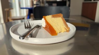 Gri tabakta bir parça vejetaryen keki. Beyaz kremalı, karamel ve fındıklı ev yapımı havuçlu kek. Yüksek kalite 4k görüntü