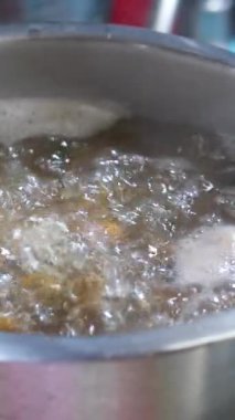 İtalyan makarnası çok yavaş bir şekilde kaynayan suyla tencereye dökülüyor ve mutfak aşçısının geleneksel yemek tarifleriyle pişiriliyor. Yüksek kalite 4k görüntü