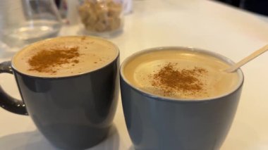 Tarçın aromalı, sütlü kahve için baharat. Tarçın perşembe geleneklerinin faydaları. Çikolata parçacıklı kafe süsleyen gri kahve fincanları. Yüksek kalite 4k görüntü