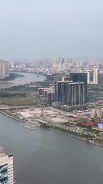 Şehrin gökdelenlerini gözler önüne seren çatı katı restoranının çarpıcı panoramik manzarası Saigon Nehri ve şehir ışıkları gece aydınlatılmış kentsel manzara Vietnam Ho Chi Minh Şehri 10.07.2025