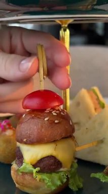 Mini hamburgerler, mini hamburgerler ve taze malzemelerle yakın plan mini hamburgerler. Yüksek kalite 4k görüntü