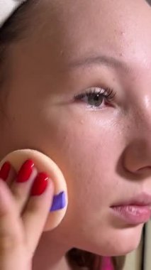 Aynada kendine bakan bir kadın pudrayı yumuşak bir pufla uygular. Kız kendine hayran ve makyajı yeniden kullanılabilir bir süngerle kaldırıyor. Yüksek kalite 4k görüntü