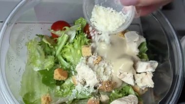 Sezar salatasını trendeki tüm malzemelerle birlikte plastik bir kabın içinde hazırlıyorum. Yüksek kalite 4k görüntü