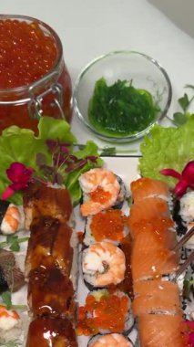 Masa baştan çıkarıcı bir suşi dizisi ile hazırlandı ve lezzetli Japon yemekleri Asya mutfağı ile dengelendi. Suşi rulolarının baştan çıkarıcı çeşitleri restoran masasının özgün tadını güzelleştirir..