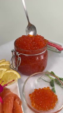 Natural fish red caviar in a cup, a man with a spoon takes the caviar and wooden table. Slow motion, 4K. High quality 4k footage