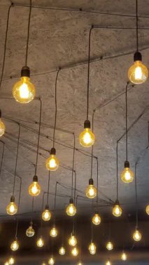 Tavan arası tarzı ev dekorasyonu restoranındaki küçük ampullerde asılı. Hafif elektrik aydınlatması var. Yüksek kalite 4k görüntü