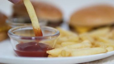 Lezzetli hamburger, büyük bir pirzola ve ketçaplı patates kızartması. Patates kızartmasını ketçapa batır.