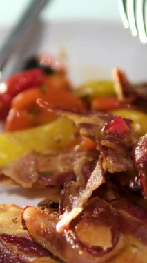 Pastırma ve sebzelerle kahvaltı yapan kişi. Pastırma çatalı sebze