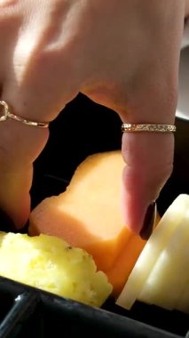 Plastik bir kabın içindeki papaya parçaları, içinde dilimlenmiş Kivano salatalığı olan şeffaf plastik konteynırla alınır ve onlardan biri çıkarılır. Yüksek kalite 4k görüntü