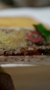 Kızarmış sığır iliği kemiği zarif bir şekilde zengin ve lezzetli bir tabakta sunuluyor ince yemek tabakları ayrıntılı doku mutfak sanatı modern restoran sunumu.