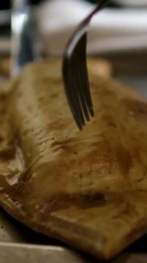 Altın hamur hamuru içinde iştah açıcı beyaz balıklar bıçak ve çatalla açılmış sulu taze eti, şık bir restoranda nefis bir deniz ürünleri sofrasında yemek için mükemmel bir şekilde ortaya çıkarıyor..