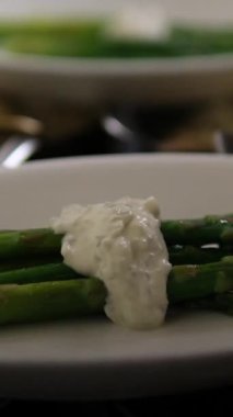 Açık büfe masasına düzgün yerleştirilmiş kuşkonmaz porsiyonlu bir sürü beyaz tabak. Restoran servisi oteli yemeği ya da sağlıklı vejetaryen etkinliği için mükemmel bir yemek sunumu..