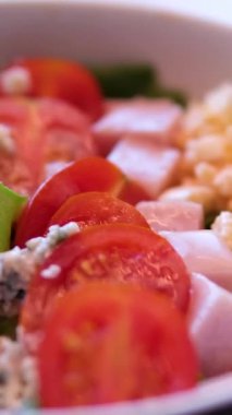 Yavaş çekimde tavukları beyaz kasede taze salataya koyan Sezar Salatası hazırlığı. Yüksek kalite 4k görüntü